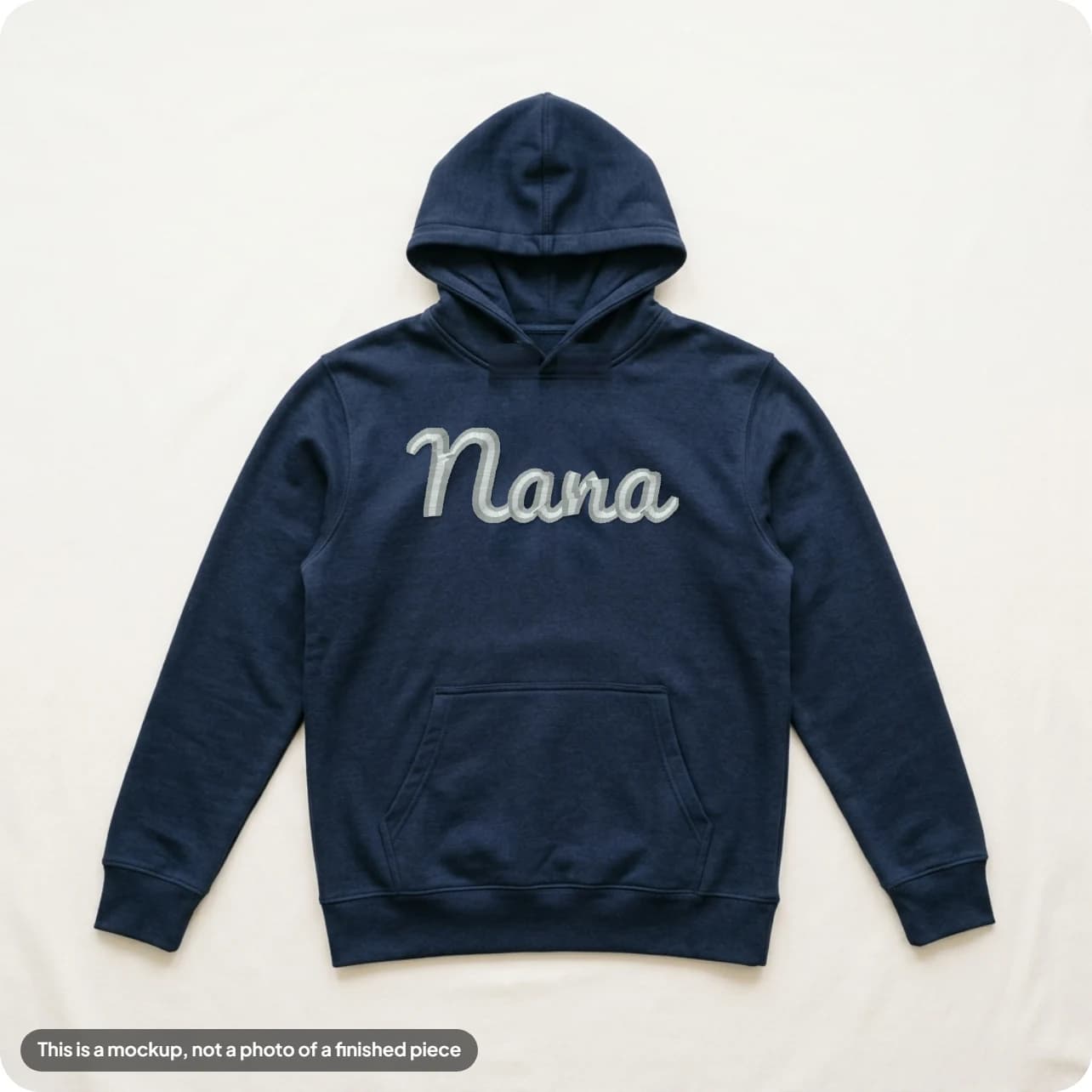 A name embroidered in light thread on a navy hoodie, built in the Mockup Studio